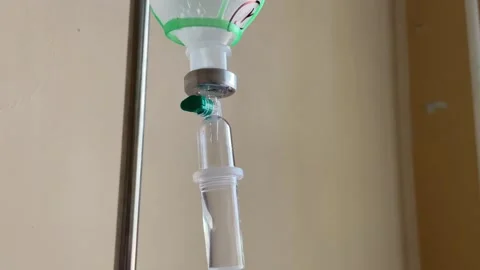Detailed close up of iv drip chamber and medication bottle during hospital .. Video stock 336071584