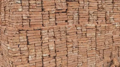 A detailed close-up of a large stack of newly made red-orange bricks, tight.. Stock Photos