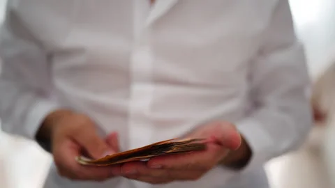 Detailed close-up of man's hands as rapidly counts wad of fifty euro bankno.. Stock Footage 340022455