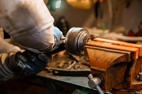 Detailed Close-Up of Mechanic Working on Engine Parts in a Workshop Foto stock