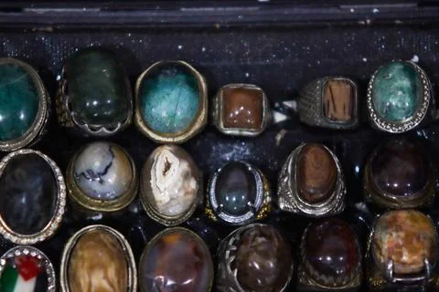 Detailed close up of organic pattern agate and jade gemstone rings in tray Stock Photos