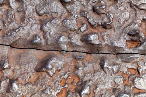 Detailed close-up of rough textured rusty metal surface with crack Stock Photos