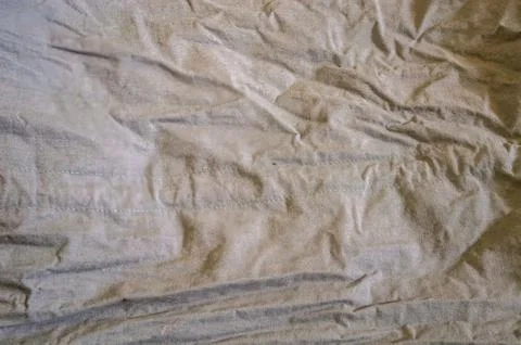 Detailed close up of a rumpled, light gray textile surface with visible sea.. Stock-Fotos