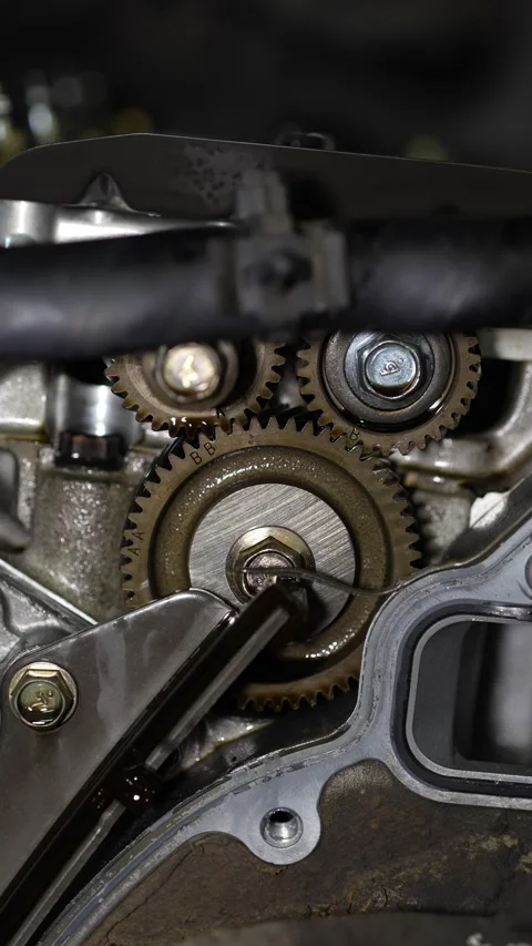 A detailed close-up shows interlocking timing gears with alignment marks insi Stock Footage 345108999