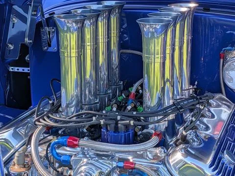 Detailed close-up of a silver V8 engine with eight polished exhaust rods Stock Photos