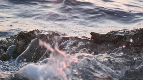 Detailed close up view of ocean waves splashing rocky shore Stock Footage 337418202