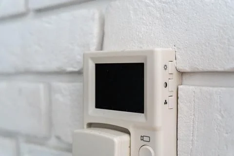 Detailed close-up of a wall-mounted temperature control unit against a white 스톡 사진