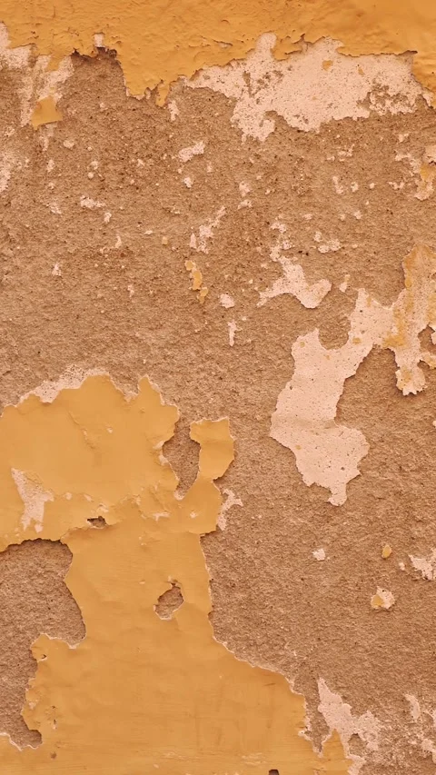 Detailed Close-up of Weathered Orange Wall Texture with Peeling Paint for Stock Footage 313986850