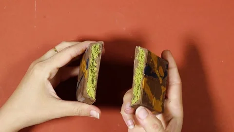 A detailed close up of a woman's hands breaking open the viral Dubai chocolate w 스톡 동영상 333051365