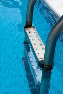 A detailed closeup view of a rusty, old ladder that leads down into a refresh 스톡 사진