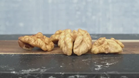 A detailed closeup view of walnut halves is artfully presented on a dark marble Stockbeeldmateriaal 288318719