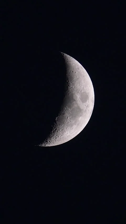 Detailed crescent moon phase glowing brightly in the dark night sky, telephoto Stock Footage 341726173