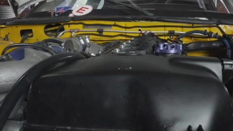 Detailed examination of engine bay components before race starts. Comprehensive Stock Footage 336868489