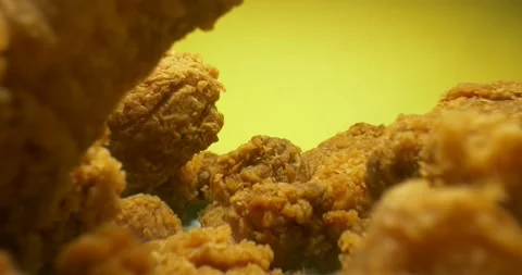 Detailed extreme close-up of breaded chicken wings and legs on yellow background Stock Footage 151214029