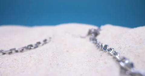 Detailed extreme close-up silver chain on white sand Stock Footage 155241468