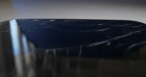 Detailed extreme close-up of the surface of a black smartphone with a broken Stock Footage 155239685