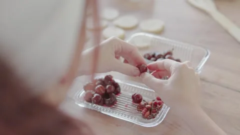 Detailed image of hands preparing fresh grapes in a transparent container on a Video stock 279921839