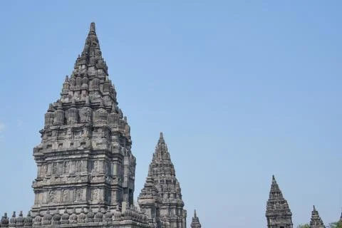 Detailed low angle view of stone spire top architecture at Prambanan temple. Stock Photos