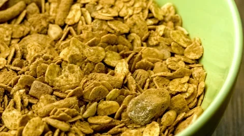Detailed macro of adding milk to chocolate flavored natural muesli cereal for Stock Footage 62799360