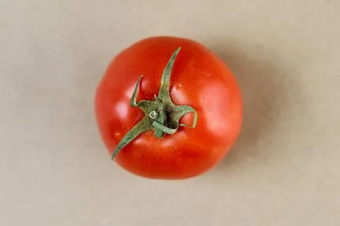 A detailed macro close-up of a single red tomato crowned with its vibrant green Stock Photos