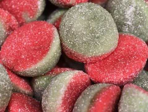 Detailed macro image capturing lively red and green gummy discs coated in Stock Photos