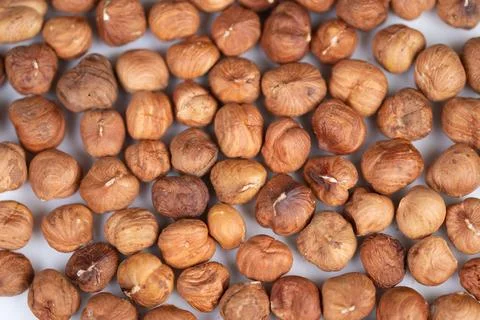 Detailed macro shot highlighting surface imperfections of roasted hazelnuts. Dis 写真素材