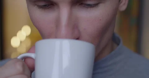 Detailed macro shot of man drinking tea coffee from white cup indoors slow Stock Footage 143053234