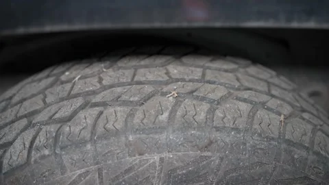 Detailed Macro Shot of Worn Tire Tread During Vehicle Inspection Under Bright Stock Footage 346338463