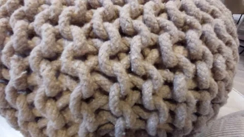 Detailed macro texture of a beige knitted pouf or braided rope cushion backgroun Stock Footage 338286778