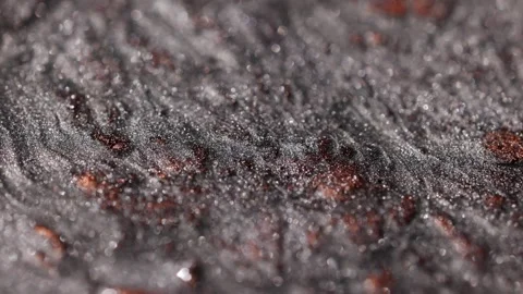 Detailed macro view of dark titanium paint with copper spots flowing slowly and Stock Footage 327603766