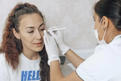 Detailed marking on the client s face highlight the expertise required in beauty Stock Photos