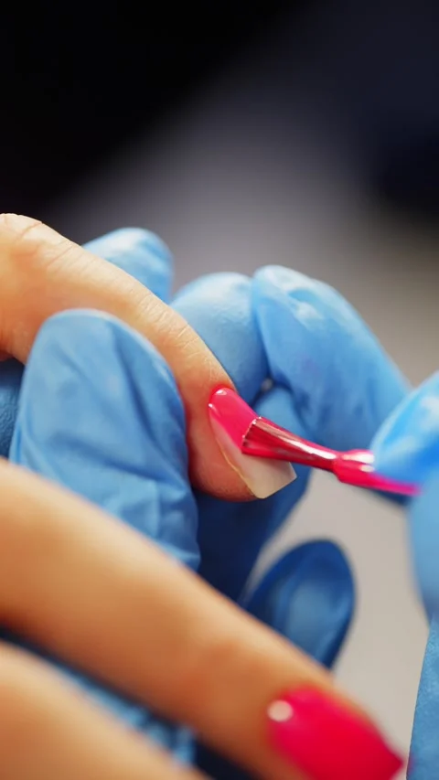 Detailed process of applying gel polish on female nails by expert manicurist Stock Footage 319879597