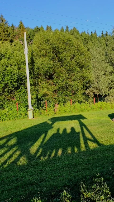 A detailed shadow of three people sitting on a covered swing bench Stock Footage 340274942