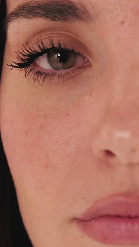 Detailed shot of half face of young woman opening her eyes and looking at camera Stock Footage 255504965