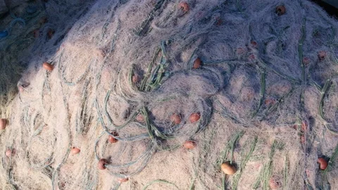 Detailed top view of a large pile of tangled fishing nets with floats Stock Footage 340186373