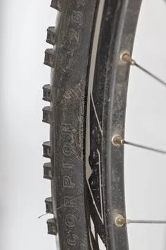 Detailed vertical close-up image of a torn black bicycle tire with visible .. 写真素材
