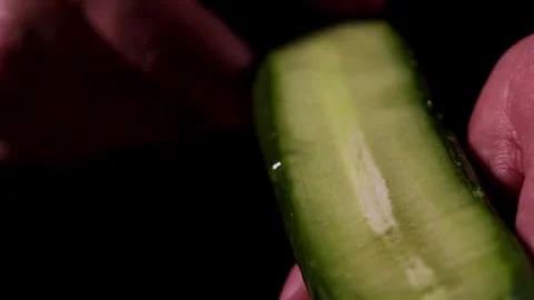 A detailed video showcasing the process of peeling a cucumber with a peeler in Stock Footage 277424940