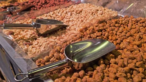 Detailed view of assorted nuts in clear bulk bins, showing cashews, peanuts Stock Footage 339849234