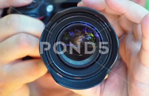 The detailed view into the camera lens of photographer taking picture Stock Photos