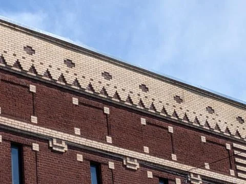 Detailed view of decorative brick patterns crowning a historic building Stock Photos