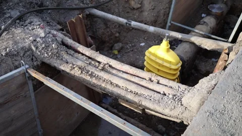 Detailed view of exposed underground cables and pipes during utility repair. Yel Stock Footage 304885318