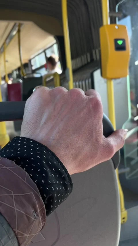 Detailed view of hand holding bus seat during morning rush in city transit Stock Footage 336435165