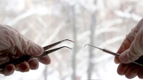 Detailed view of a hand holding precision tools during an eyelash extension Stock Footage 326837765