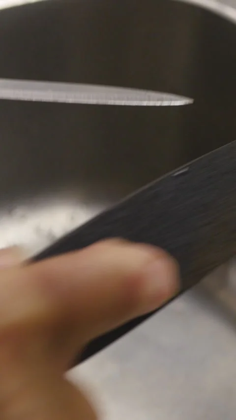 Detailed View Of A Hand Sharpening A Kitchen Knife Using A Whetstone, Enhancing  Stock Footage 312964712
