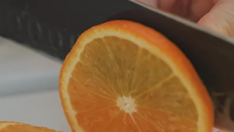 Detailed view of hand slicing bright orange peel skillfully. Macro shot Stock Footage 332284255