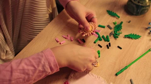 Detailed view of hands assembling flower petals on wood surface Stock Footage 335780335