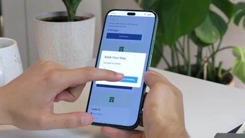 Detailed view of hands finalizing a hotel booking on a mobile device Stock Footage 315175570