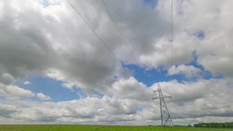 A detailed view of a high-voltage power tower standing tall with several cables Vídeo Stock 313348767