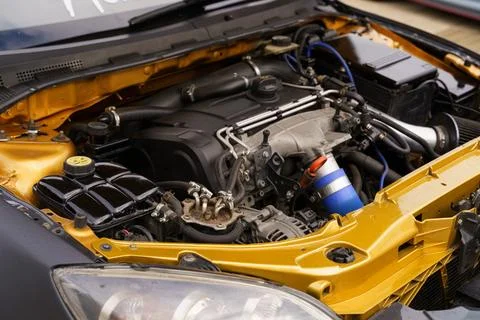 Detailed view of a modified car engine with striking golden accents 스톡 사진