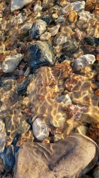 Detailed View of Multi-Colored Pebbles in Clear Water Stock Photos